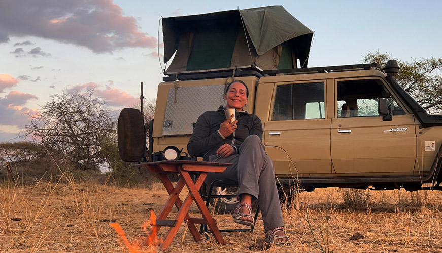 Ulrike Nehls mit Landcruiser, Dachzelt und Lagerfeuer im Tarangire Nationalpark in Tansania