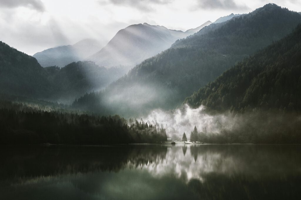 Berge und Nebel in der werden von einem See reflektiert